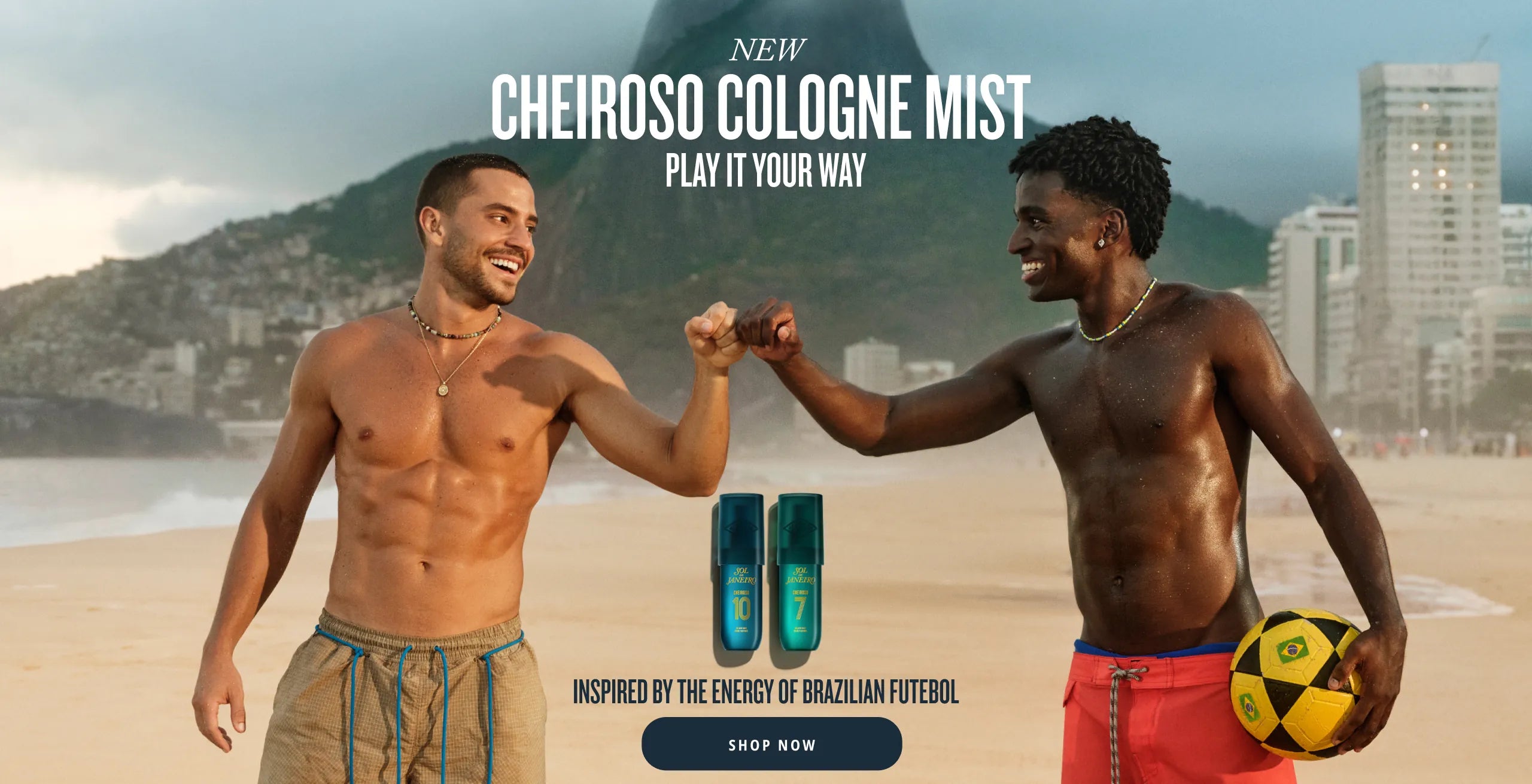 Sol de Janeiro Cheiroso Cologne Mist campaign featuring two men fist-bumping on a beach with a soccer ball. Text: Inspired by the energy of Brazilian Futebol. Shop Now.